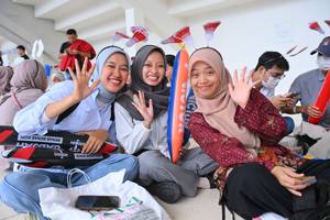 Tiga penonton berpose untuk foto saat mengantri masuk Istora GBK (Djarum Badminton)